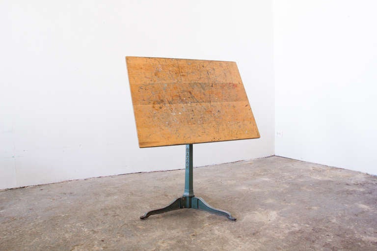 A Saxon drafting table with a three-legged steel pedestal base of a greenish hue. It adjusts vertically, and swivels on an axis to various degrees. The tabletop can be adjusted to be parallel to the ground.

Parallel tabletop dimension:

Height