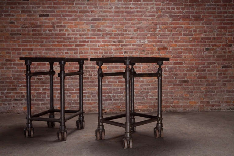Pair of steel turtle tables with cast iron wheels, made in the US.