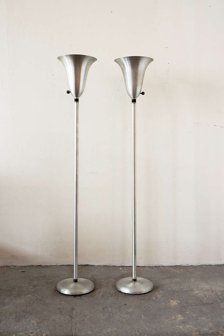 A set of American art deco floor lamps designed and produced by Russel Wright (1904-1976). The lamps have a spun aluminum bowl, base and shaft with wrapped brass wire detailing. The base is marked â??Russel Wright NYCâ??.