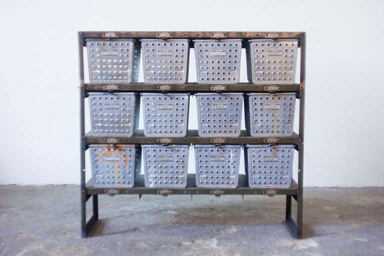 A well-worn twelve cubby gym locker bank by Lyon. This piece has a thin profile, and features galvanized steel ventilated privacy containers.
