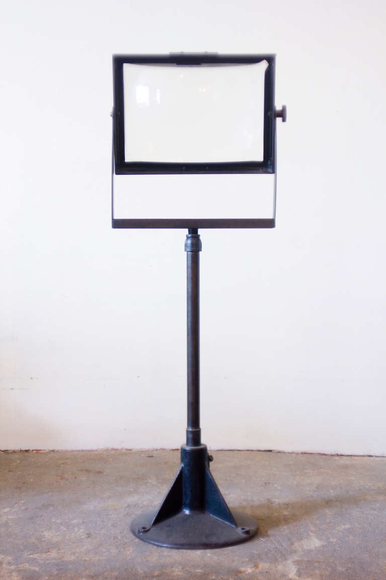 This standing, adjustable magnifier lens will prove to be a source of endless design possibilities, in the way it effects light, and in its presence in a room. From cast-iron and an antique television screen, the magnifier is one of a kind.