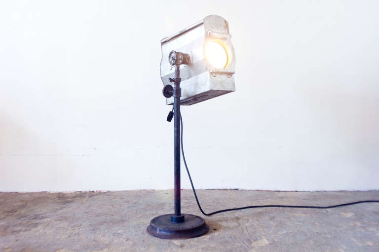This display stage lighting co. stage lamp, mounted on a substantial iron base, emits a spot beam. It opens from the side, allowing for the changing of bulbs and turns on via a rocker switch.

Measures: Tallest: 68