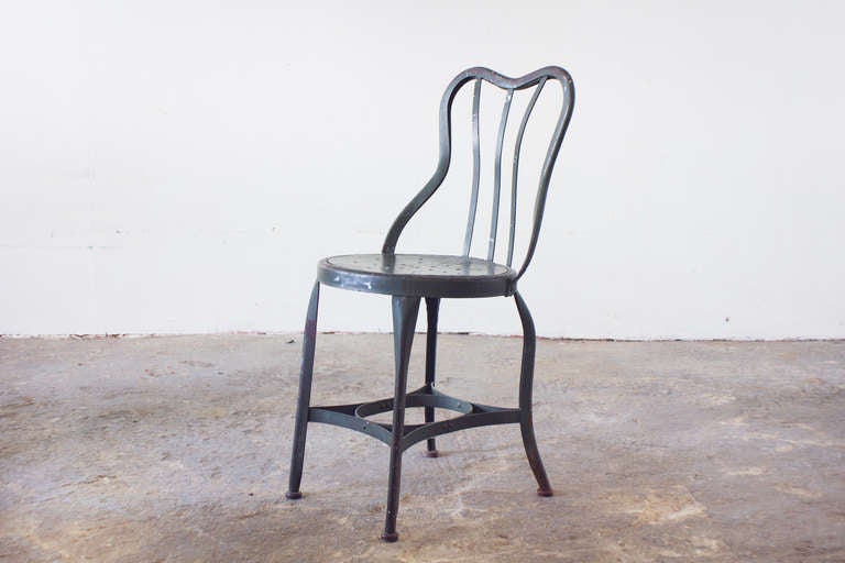 This steel chair is a Toledo classic, with a perforated seat and heart shaped back. It is comfortable, durable, and desirably patinated.
