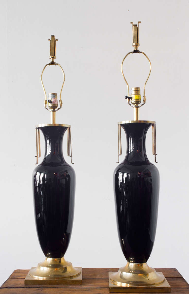 These vase shaped black onyx table lamps by Chapman feature elegant brass tassels, and stand on solid sculptural bases.