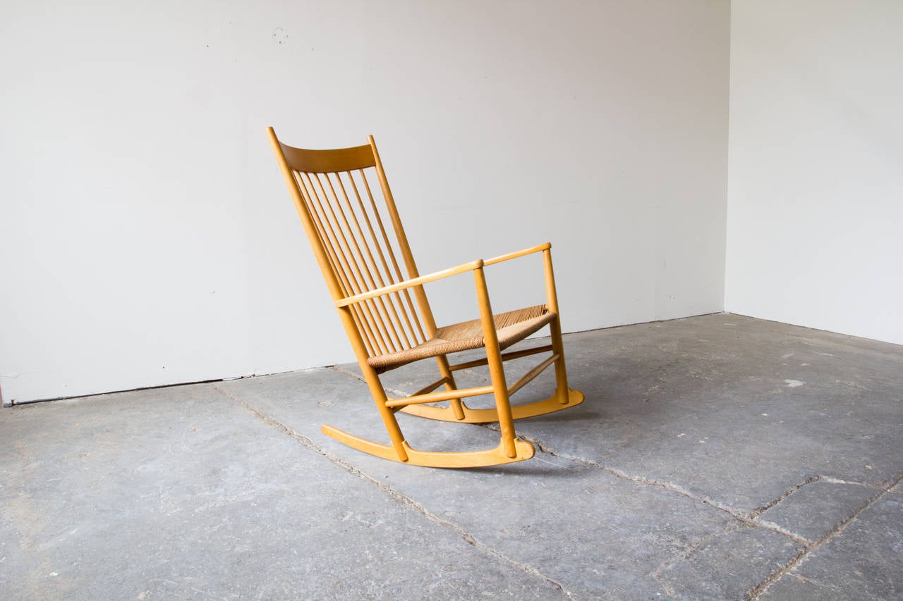 A beech rocking chair by Hans Wegner for FDB Møbler. In production since 1944, the design was largely a reference to the construction of Shaker rocking chairs. The woven paper cord seat is original and maintains its strength.