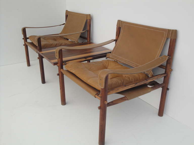 Arne Norell South American Santos rosewood safari lounge chairs with removable table made by Scanform
Measure: Each chair is 28.5" high, 26"wide and 26"deep.