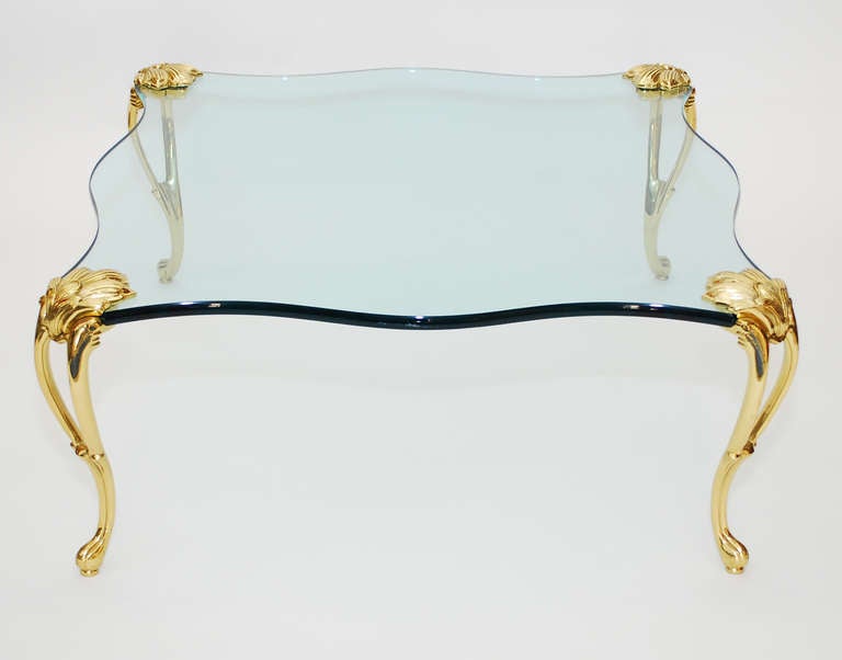 Brass and glass coffee table attributed to Maison Jansen. Finely detailed brass legs.