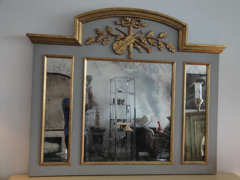 Exquisite elegantly handcarved french style parcel gilt trumeau with antiqued mirror.