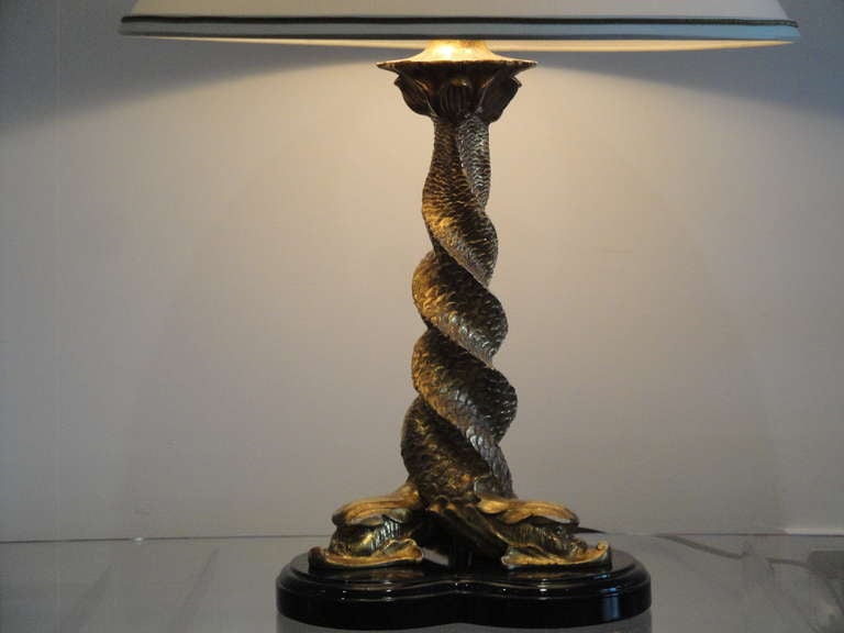 Beautiful and elegantly handcarved parcel gilt dolphin lamp.  Dimensions for height is from base to finial and diameter is base.