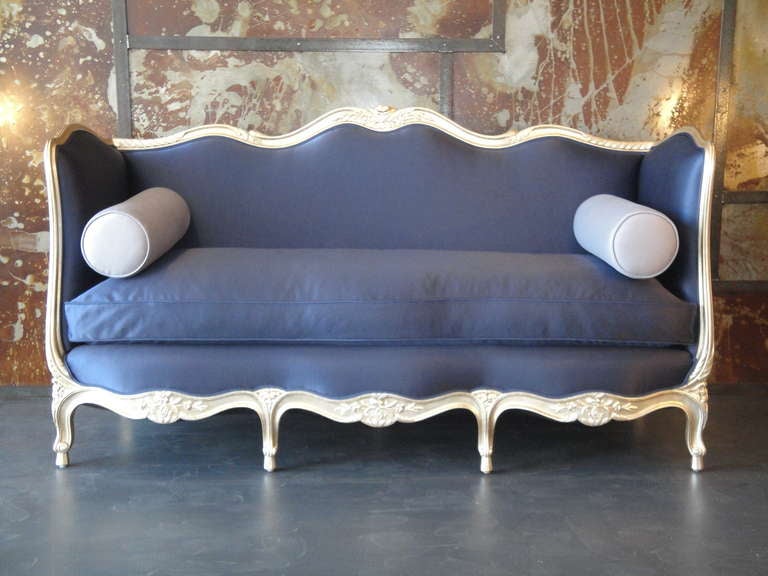 Elegantly hand carved giltwood 30's French canape reupholstered in navy blue fabric.