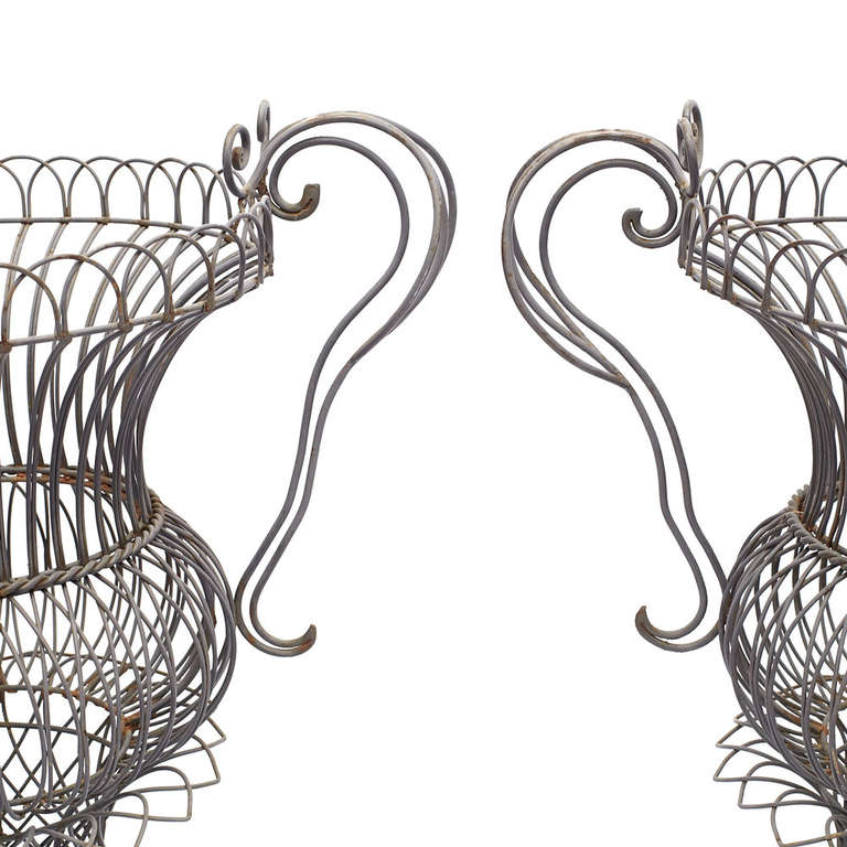 A wonderful pair of metal wire frame garden vases each in an urn form.  American, circa 1950s.

Good vintage condition.