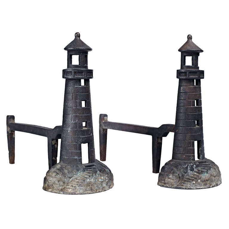 A pair of wrought iron andirons in a lighthouse form, with relief details throughout.  American, circa 1920s.

Excellent vintage condition, recently cleaned.