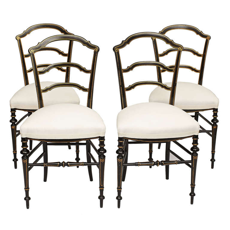 A set of four petite side chairs with ladder backs, upholstered seats and turned legs, all in ebonized wood with gilded accents.  French, early 20th century.

Good vintage condition, newly upholstered.