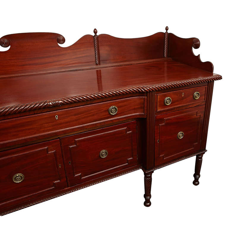 Fine Regency period mahogany sideboard with carved gallery and twist border to the top, comprised of three drawers above four doors and all resting on turned legs, Ireland, circa 1830.

Excellent antique condition.