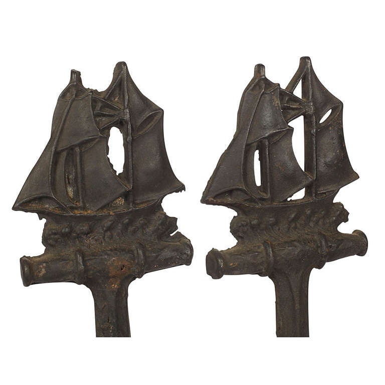 A pair of early 20th c. American cast iron nautical motif andirons. Sturdy cast iron andirons with clipper ship tops and anchor-like bodies.