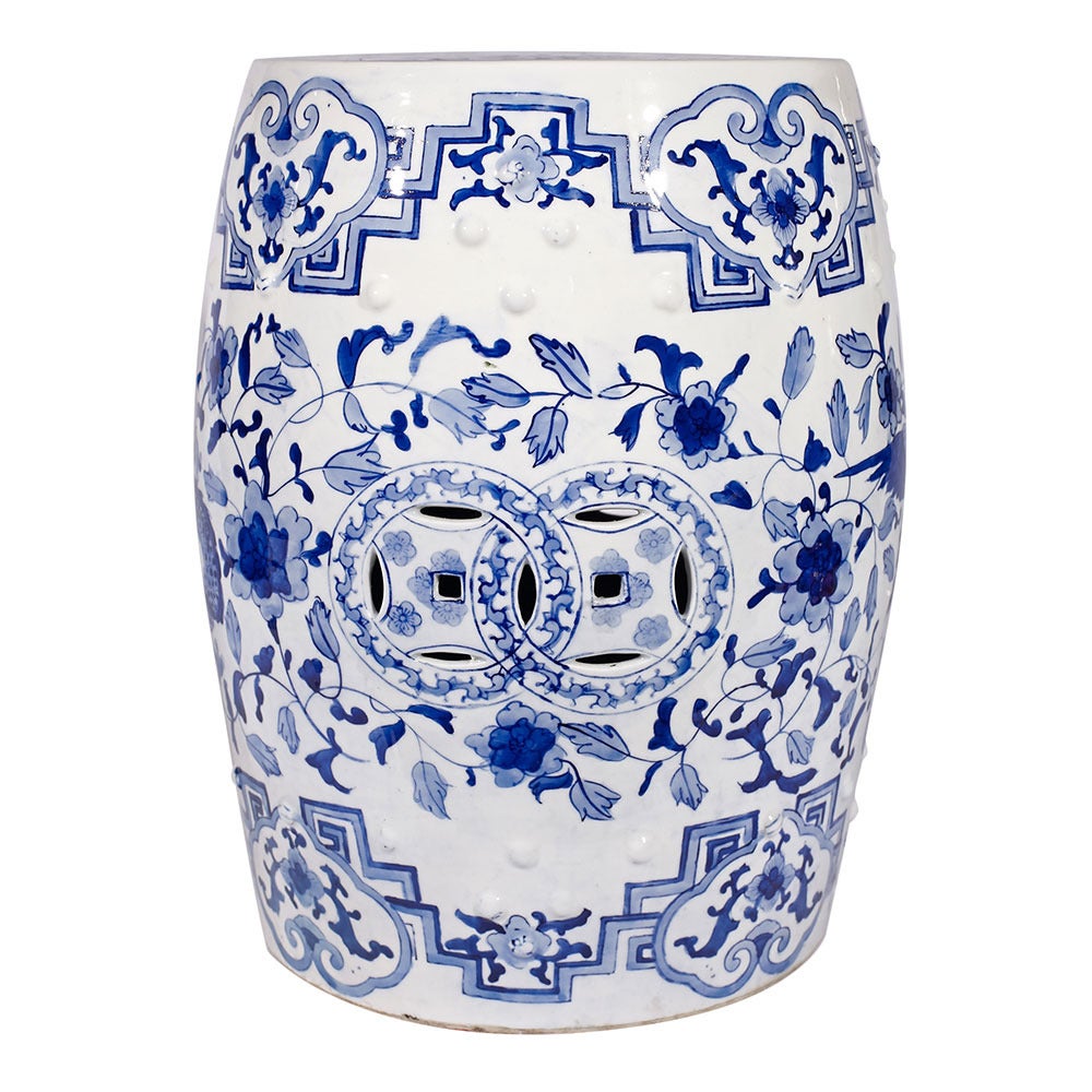 A ceramic garden stool with a white ground and blue decoration of Chinese art of birds and dragons.