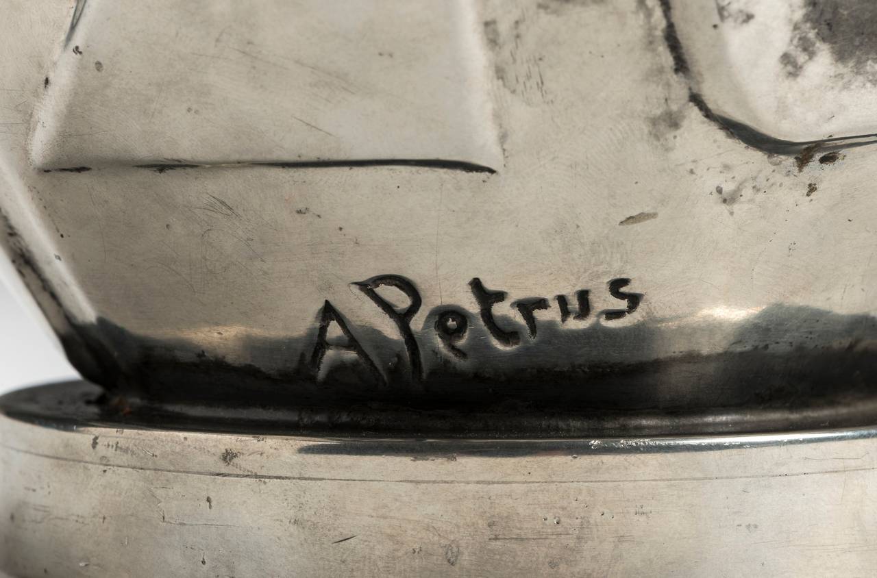 The depicted profile vase of pewter was designed by one of the earlier Svenskt Tenn artists, Anna Petrus, in 1928. The stamps under the vase show as follows: city stamp for Stockholm (crowned king St Erik), the s.c. angel mark for Svenskt Tenn