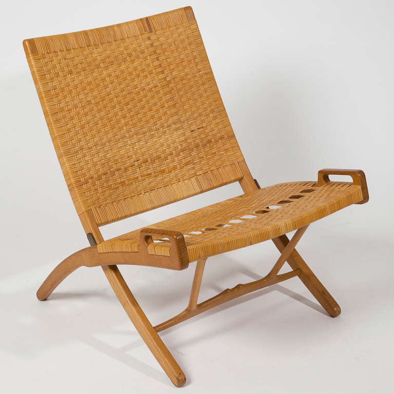 Designed 1949. Oak frame, cane woven seat and back, for Johannes Hansen. Wegnerâ??s ambition was to create an armchair, which could be stowed away easily. He solved this by designing a chair which can be hung on the wall. Wegner made his solution