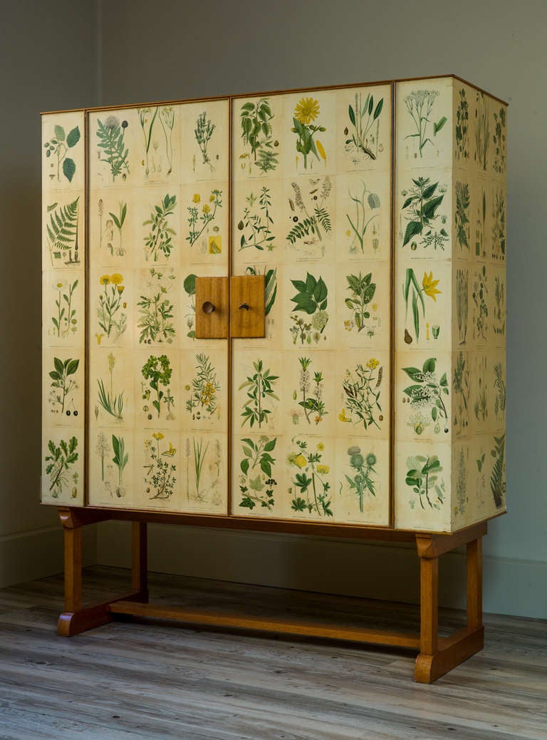 This cabinet-on-stands was designed in 1937 and decorated with illustrations from the book 