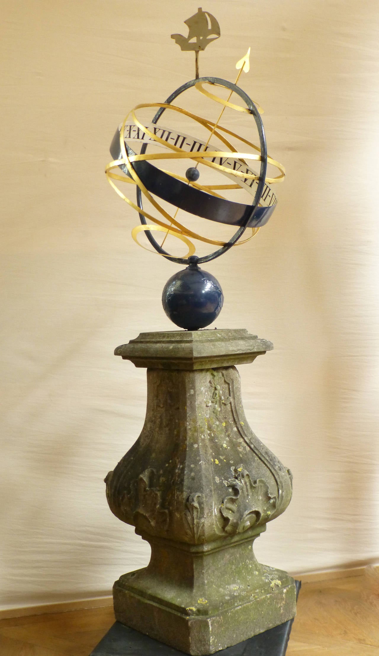 With iron armillary sphere.

In the 18th century the armillary sundial became popular. It was favored because of its ornamental appearance in the garden. More sculpture than timepiece, it’s closely akin to the horological or time-telling sphere.