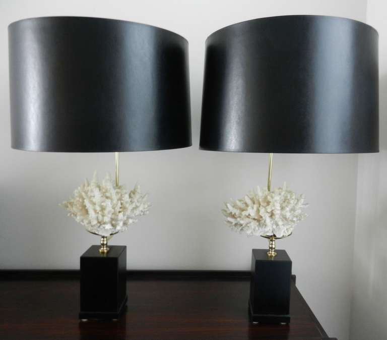 Pair of imposing French brass table lamps sitting on black marble bases with black shades and coral detail.