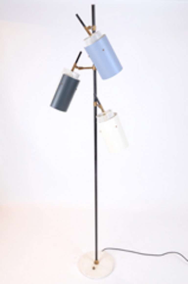 Good quality articulated floor lamp sitting on a white marble base. The lamp has a black lacquered metal stem, brass arm and lacquered metal and perforated metal shades. The shades are lacquered in white, dark grey and blue grey.