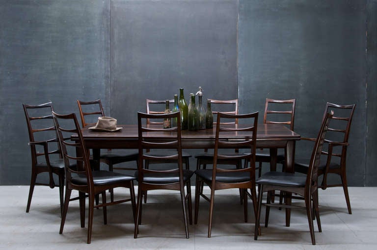 A Stunning Vintage Danish Modern Mid-Century Rosewood Dining Set. The Largest Table of this form produced.  Designed by Neils O. Moller, and made by Cabentmaker J.L. Moller.  Matched with Solid Rosewood High Ladder Back Chairs Designed by Neils O.
