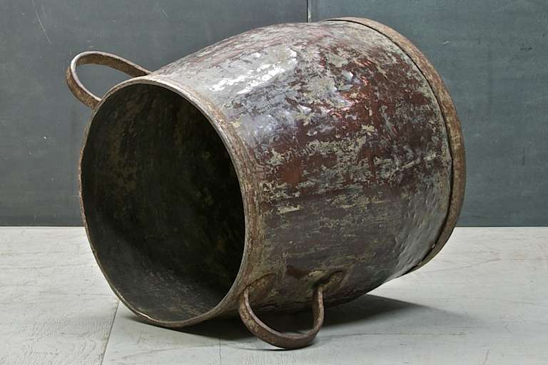 Rustic Vintage Early 19th Century monumental copper water caldron. Incredible patina to copper. As firewood holder.
 
 Measures: W 30½ x H 24 in. (Diameter top: 20¼, diameter bottom: 23 in).