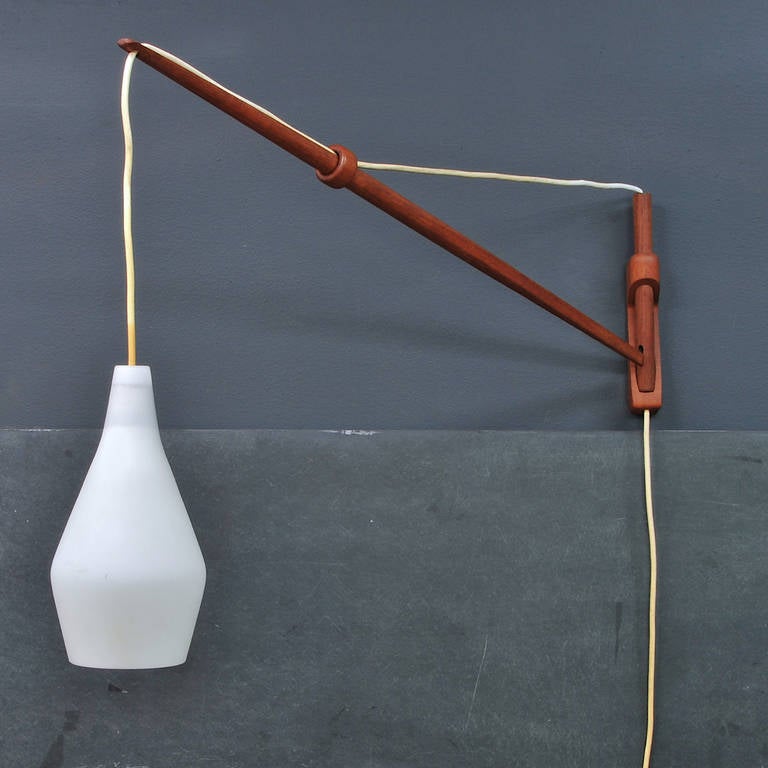 Early and Rare Teak Arc Wall Lamp designed by Lisa Johansson Pape, Made in Finland.  Design with Cord to Adjust Lamp Shaft Angle.

W: 6 x D: 33 x H: 20 in.