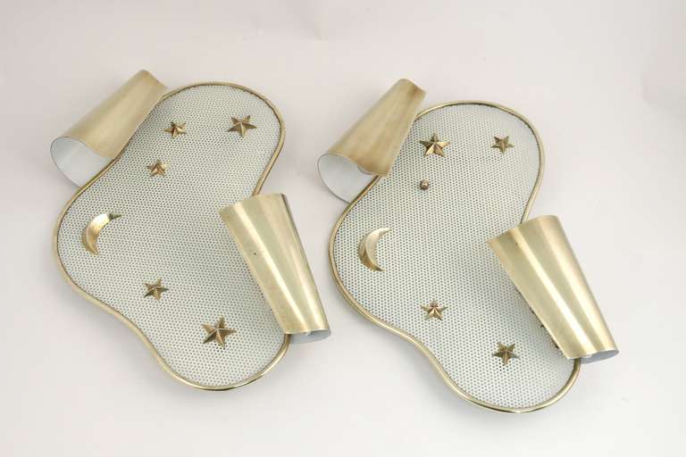Pair of 1950 Kobis et Lorence sconces in perforated sheet steel with brass inlays representing stars and moons. Two light per sconce covered by a rolled brass sheet.