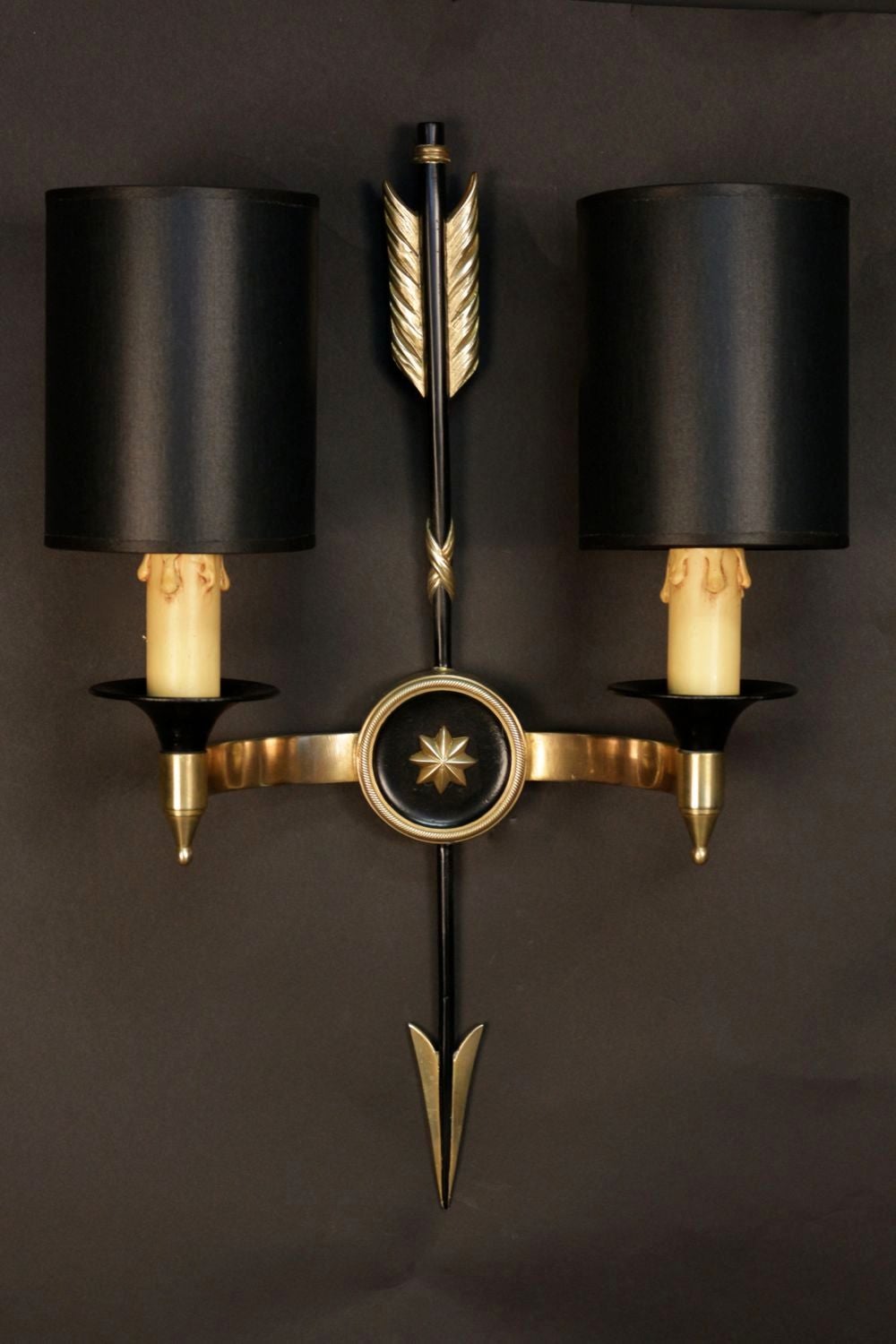 Pair of 1950s 'Arrow' neoclassical sconces by Maison Arlus. Gilded and blackened brass. Decorated with an arrow adorned with a two stars medallion. Two lighted arms per sconce and new tailored black lamp shade with gilded inside.