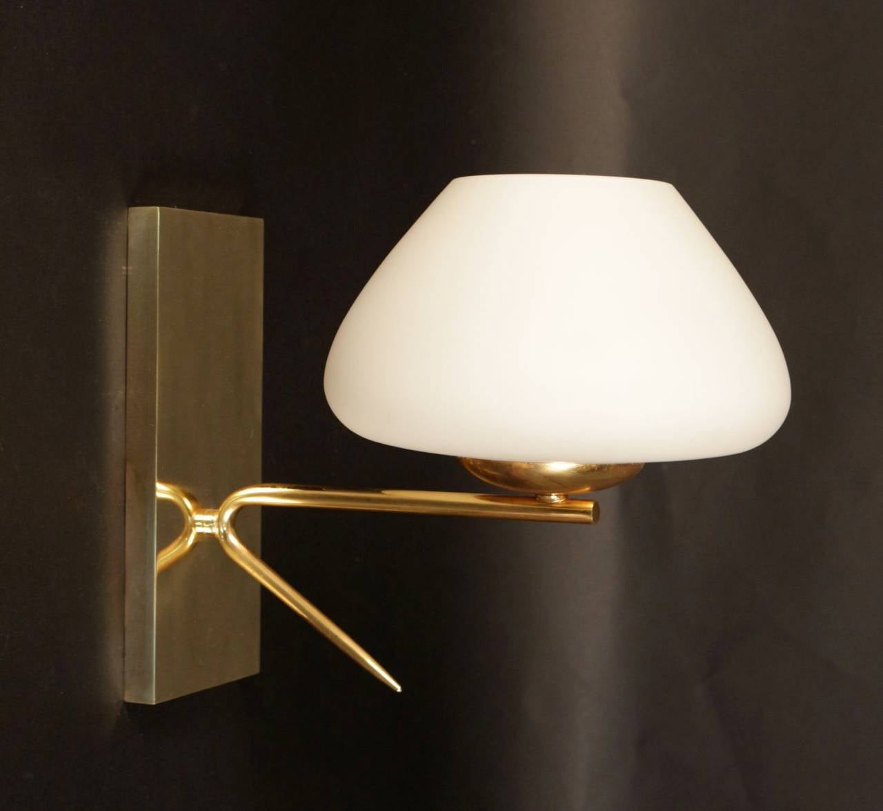 Pair of 1950s Stilnovo sconces in gilt brass embellished with an opaline cup. One lighted arm per sconce.