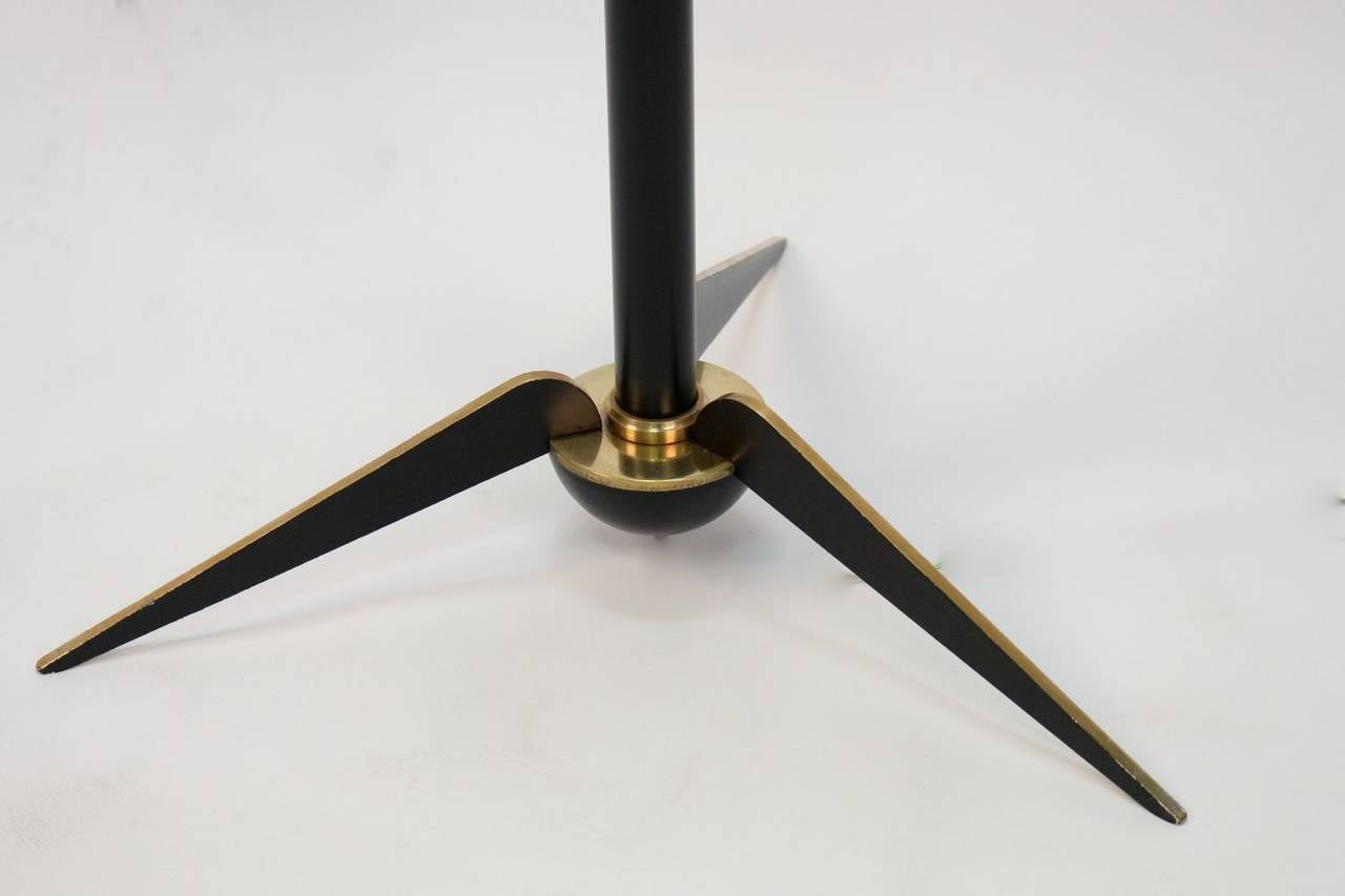 1970's floor lamp by Maison Lunel.
Gilt brass tripod legs and blackened brass front.
The lower part of the barrel is in blackened brass and the top in gilt brass.
New custom lampshade, black exterior, gold interior.
One lighted arm.