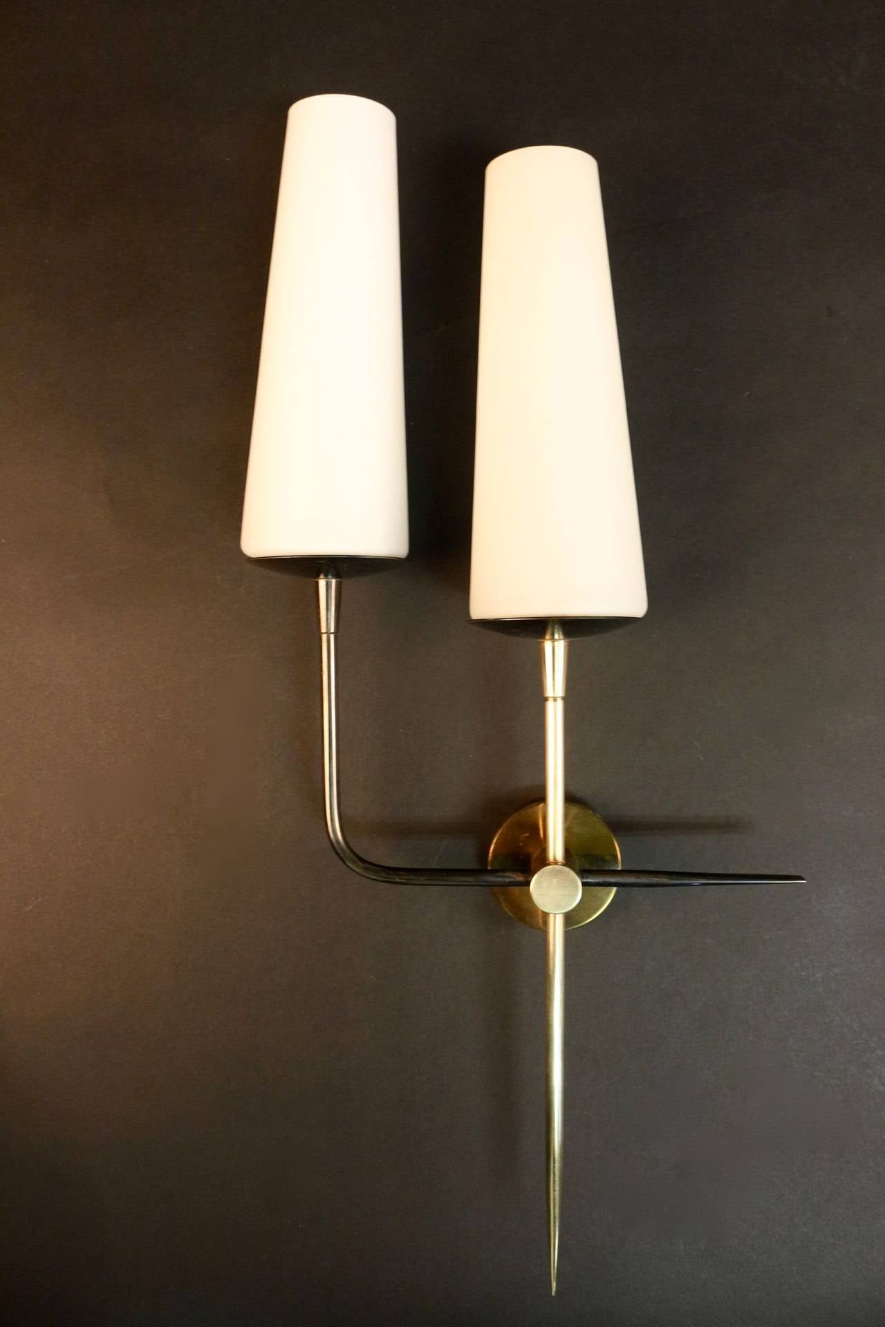 Pair of 1950s asymmetrical sconces by Maison Arlus. Gilt and 'canon de fusil' brass. Two lights per sconce decorated with opalins.