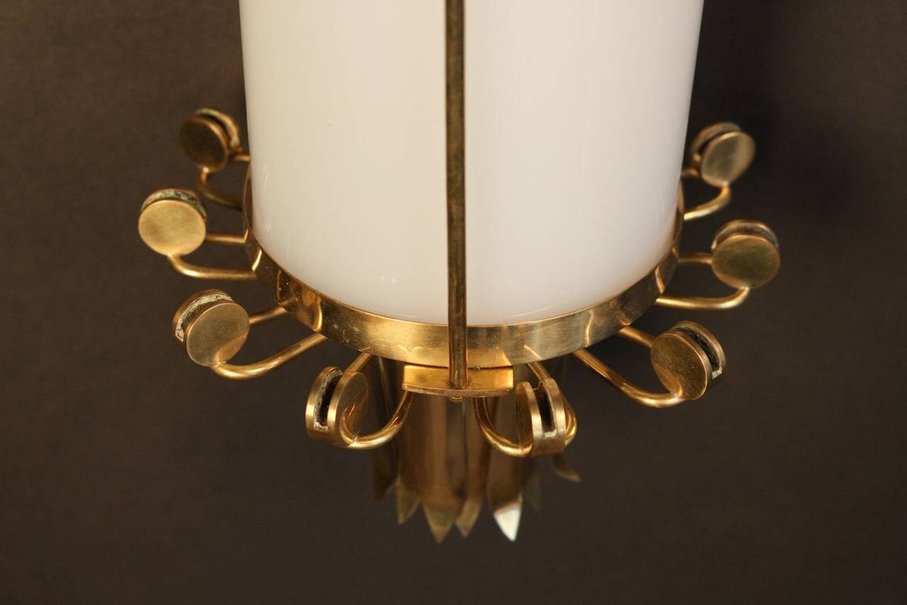 Set of three 1950s sconces by Maison Lunel. Nice brass work made of foliage on the top and the bottom of the sconces. Altuglas trunk adorned with a vertical brass bar. New wiring. Six bulbs inside each sconce.