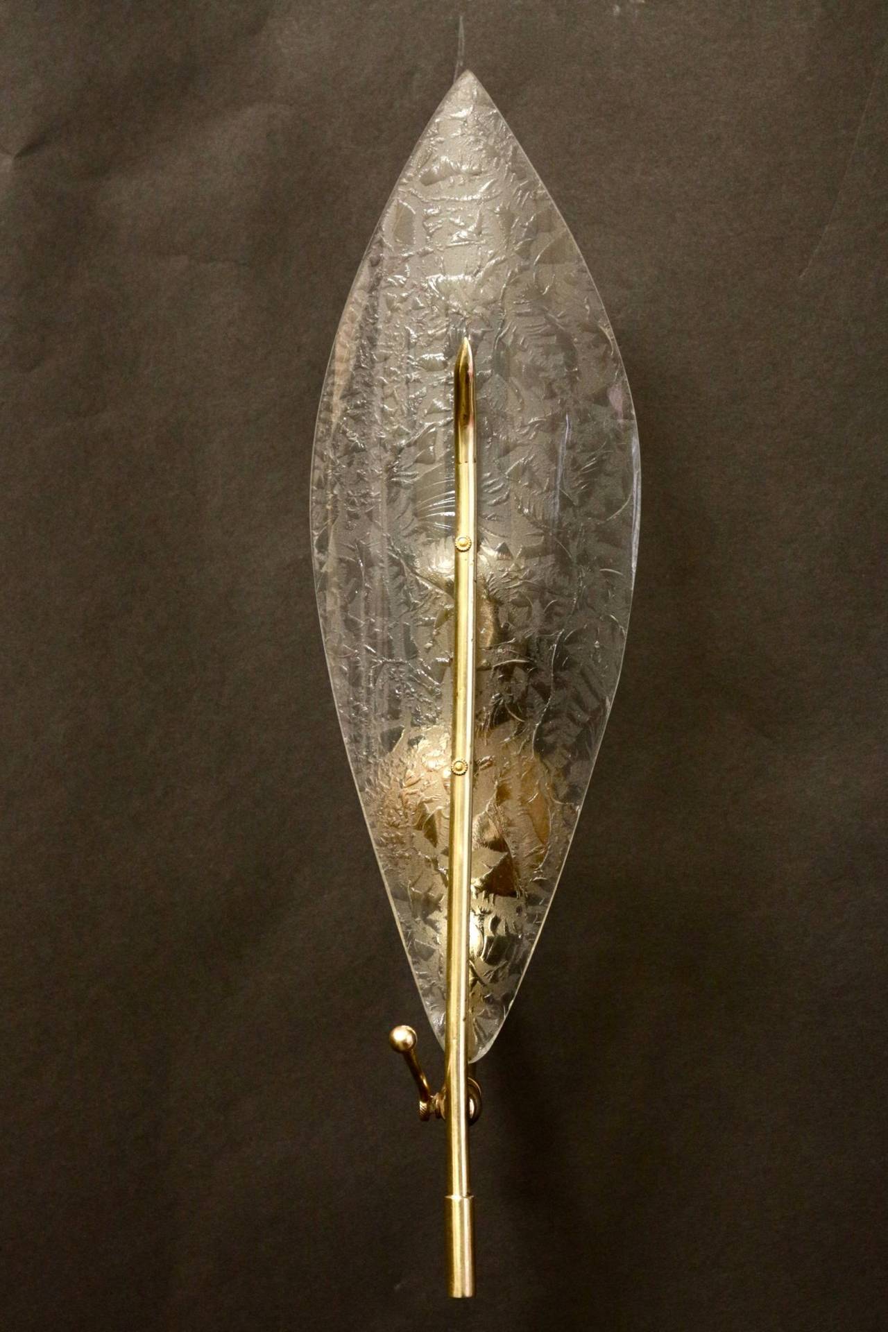 Pair of 1960s sconces attributed to Stilnovo composed of a Murano glass leave and a brass rod. Brass rod rack allows vertical inclination of the leave. One light arm per sconce.
