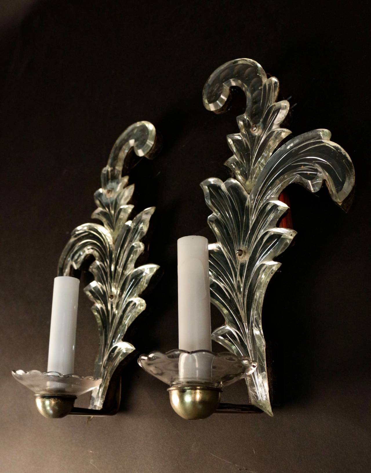 Pair of 1950s 'Acanthus Leaf Sconces' in Murano églomisé glass.
One lighted arm adorned with opaline candles and a glass cup underlined by a gilt brass half moon.