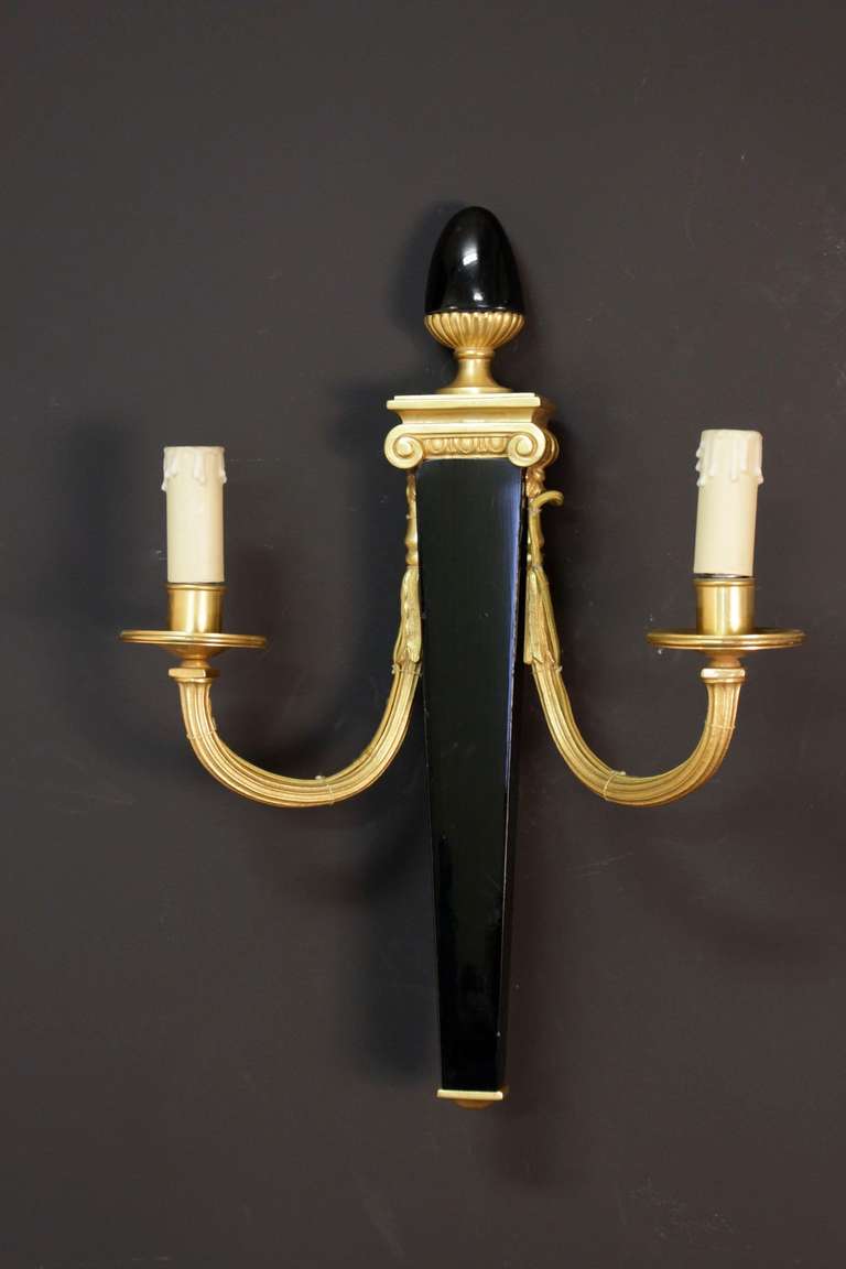 Set of four 1990s bronze sconces signed by Maison Bagues (see photo). Black China lacquer trunk. Inspired by the Restauration style. Two lighted arms per sconce. Wired for European use.