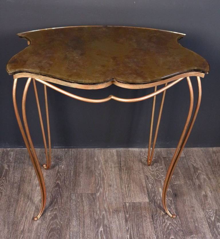 1940s Console by Rene Drouet. Gilded wrought iron feet. 
The feet have dual spirals are decorated with ball endings. 
'Eglomise' top glass with oxidisied gold leaf.