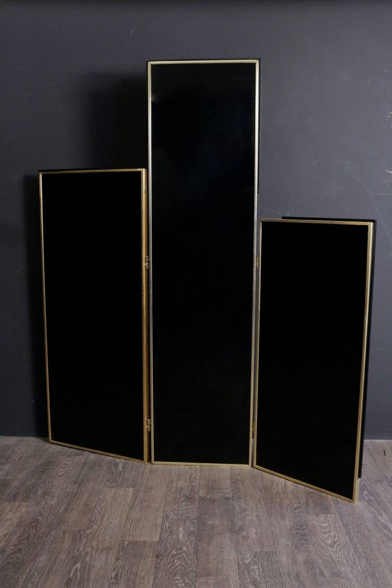 Asymmetrical 1972 screen by Maison Roche in black lacquer. 
Double sided framed with gilded bronze enhanced by a black stick. 
Three panels of different heights.