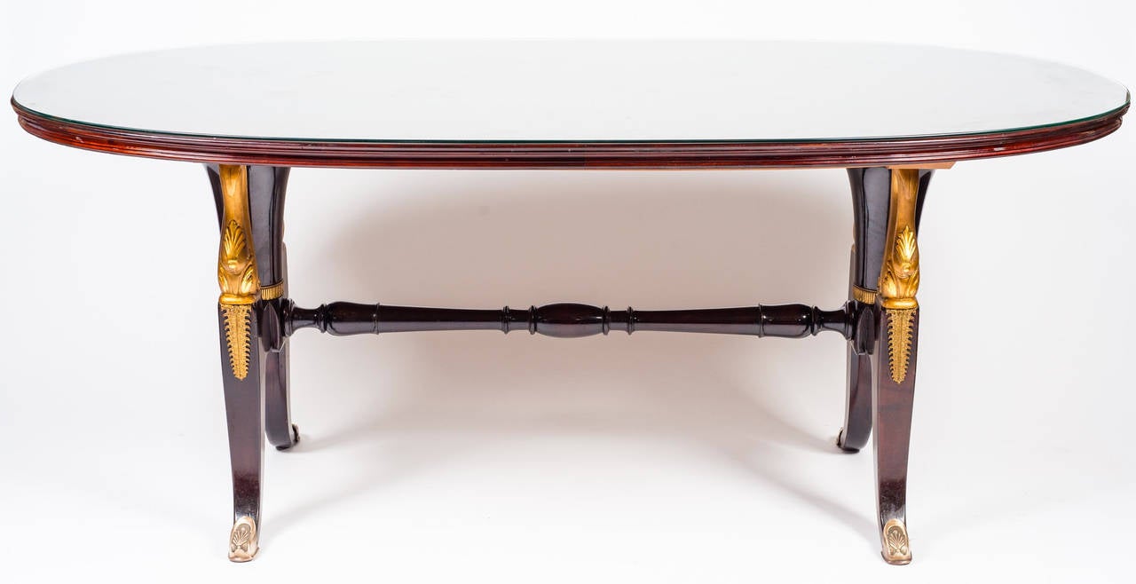Extraordinary massive mahogany table in the style of Paolo Buffa. Decorations and finishes in gold. Glass shelf.