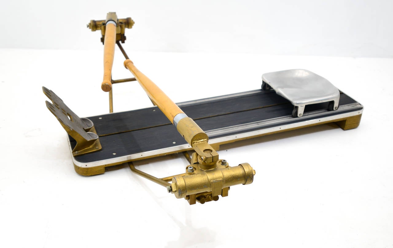 Piece of exercise equipment. 
It is constructed using solid wood with cast iron oar braces, cast iron foot rest and metal seat and track. The oar handles are authentic and are made of solid wood. The oars operate on a two hydraulic type canisters