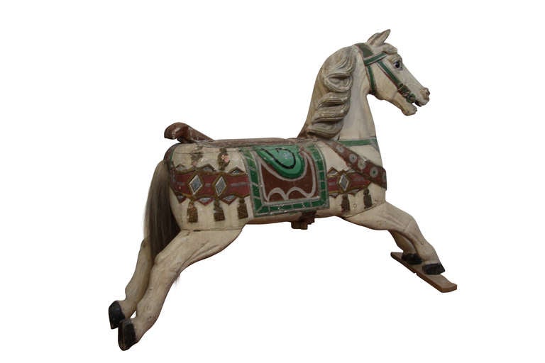 Old carousel horse, in carved and decorated wood, from Germany. Glass eyes and hairy tail.  Such a beautiful item with a touch of outdated charm!