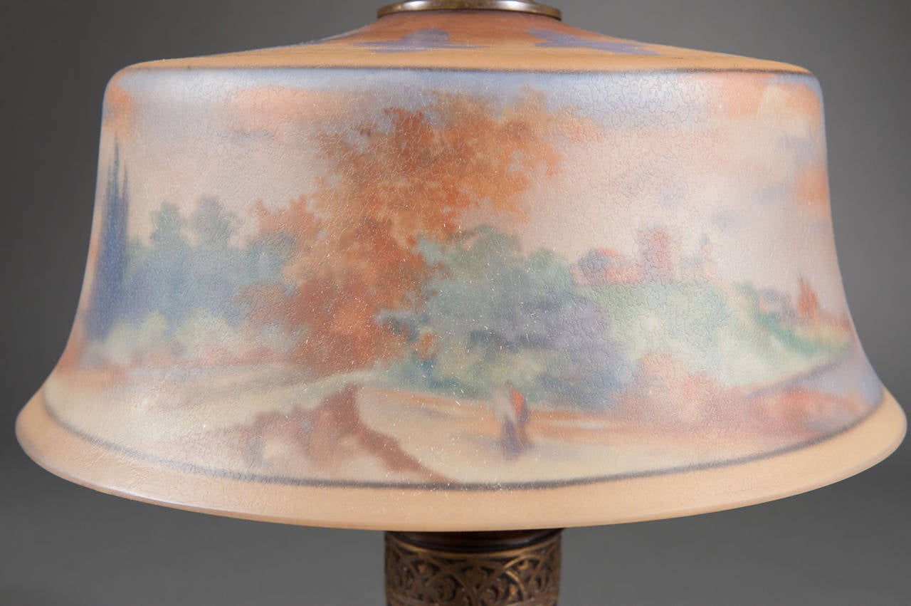 A Reverse Painted Pairpoint Landscape Lamp with Carved Wooden Base
Unites States, Circa 19th Century
Signed: The Pairpoint Corp
Dimensions: Height: 22.5