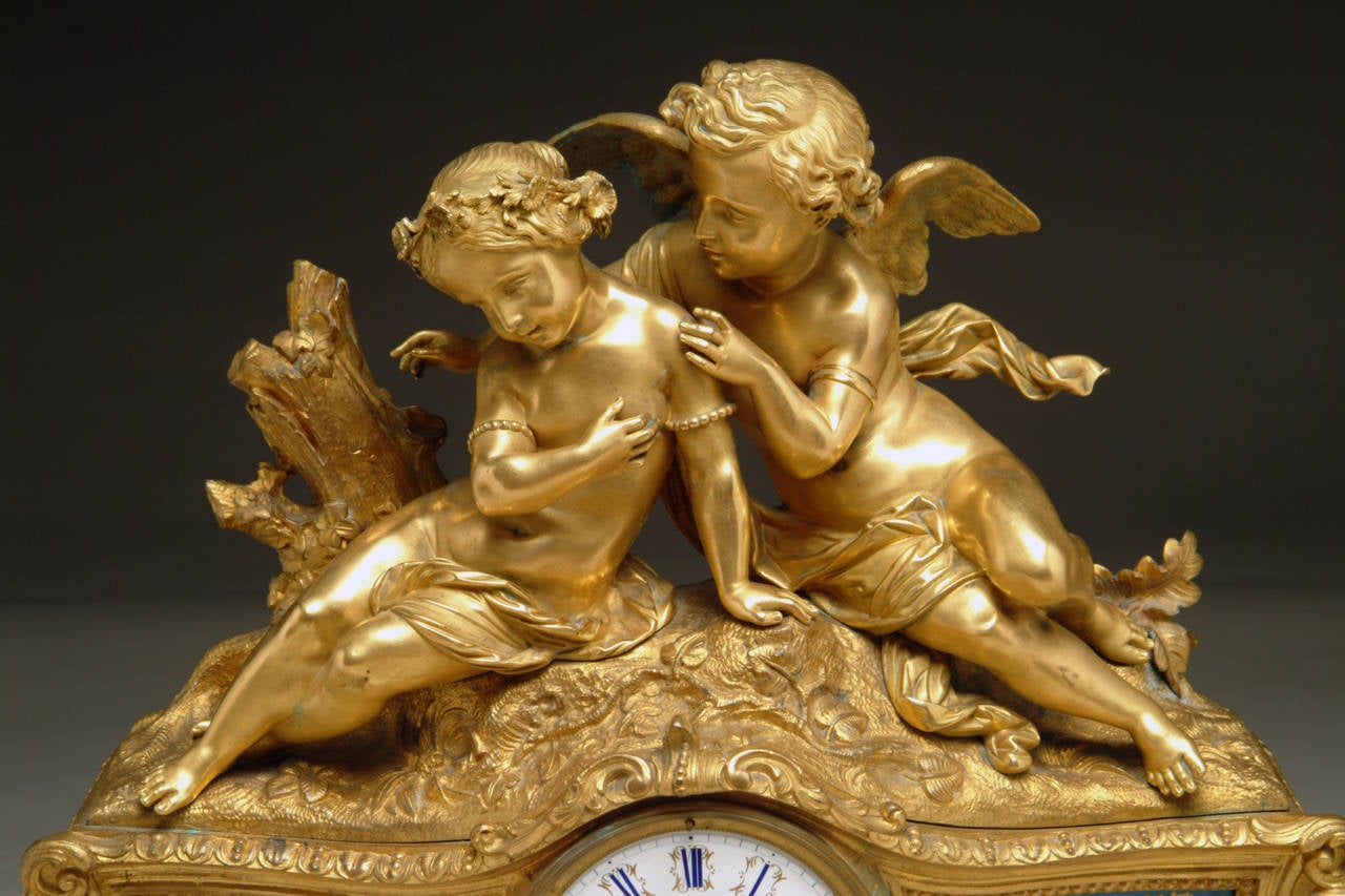 A French gilt bronze and Sevres style porcelain figural clock depicting lovers.

Paris, circa 1890.

Having two winged cherubs on each side of the gold and black numerical dial.

Dimensions: Height: 18