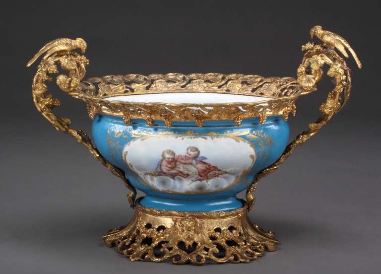 A French Sevres Porcelain Ormolu Bronze Mounted Turquoise Center Groundpiece.
The front painted with two cherubs sitting on clouds, the rear with a bouquet of flowers. Mounted with two birds on the handles.
Marked with under glazed Sevres