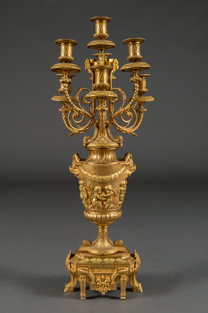This finely cast and finished pair of French Ormolu candelabras are clearly a work of a master bronzier.
Each candelabra consisting of an urn decorated with a continuous relief frieze of cherubs goats and garland superbly chased scenes of cherubs at