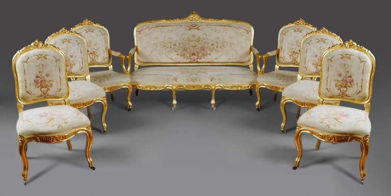 Fine French Napoleon III period Louis XV style 7-piece parlor set. This beautiful carved giltwood set is richly upholstered in handwoven Aubusson Floral Tapestry. Comprising a Canape, Four side chairs and two armchairs 
(Fauteuils).
Each chair