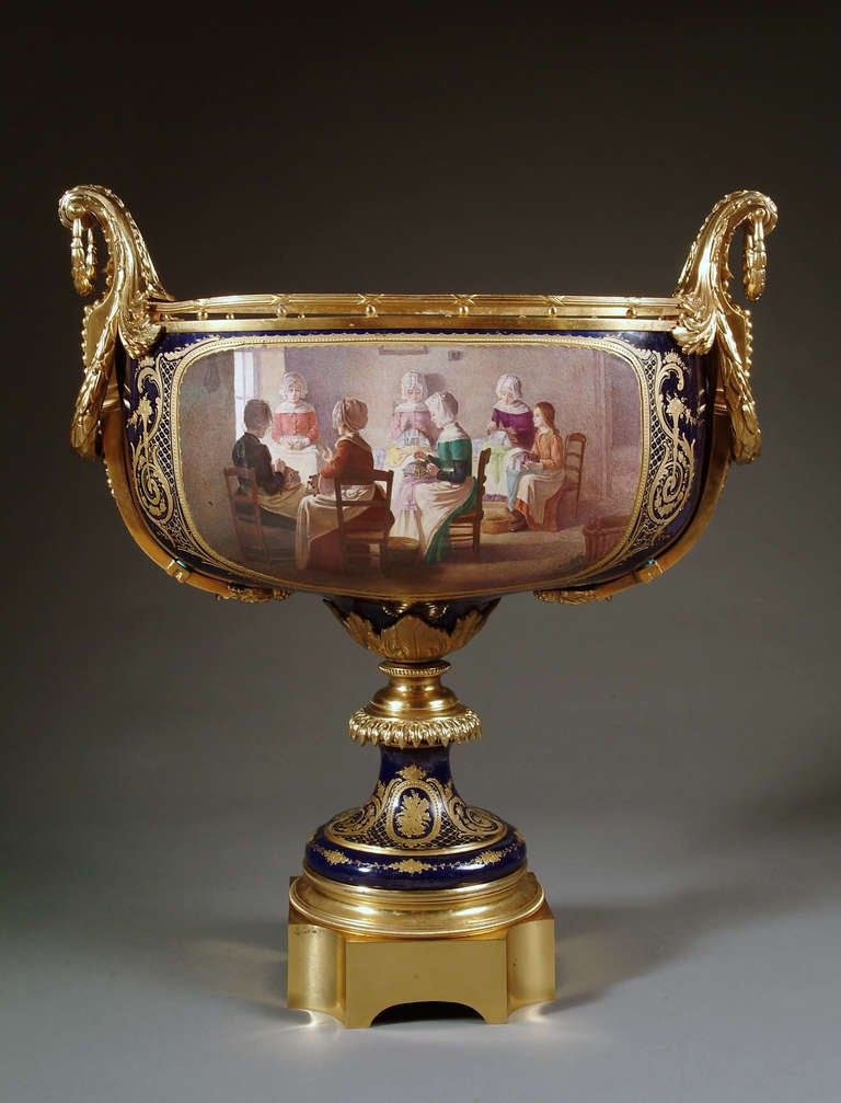 A large and unusual 19th century French Sevres style gilt bronze mounted oval shaped centerpiece. The cobalt Blue ground painted with a scene of seven ladies sitting in an interior engaging in embroidery. The reverse painted with a landscape scene