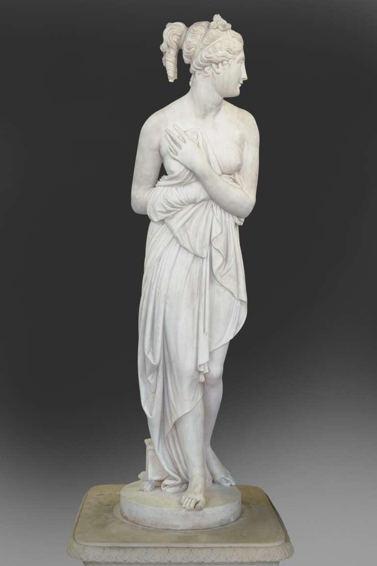 A fine 19th century Italian Hand carved Carrara Neo-Classical style sculpture of a woman draped in a cloth, set on a round plinth with a small casket draped in a cloth, with a jewelry casket at her feet.set on a round plinth.
After the model by